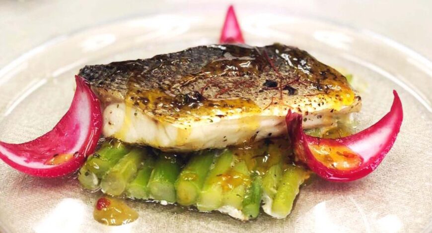 Lubina con salsa de maracuyá sobre cama de espárragos confitados