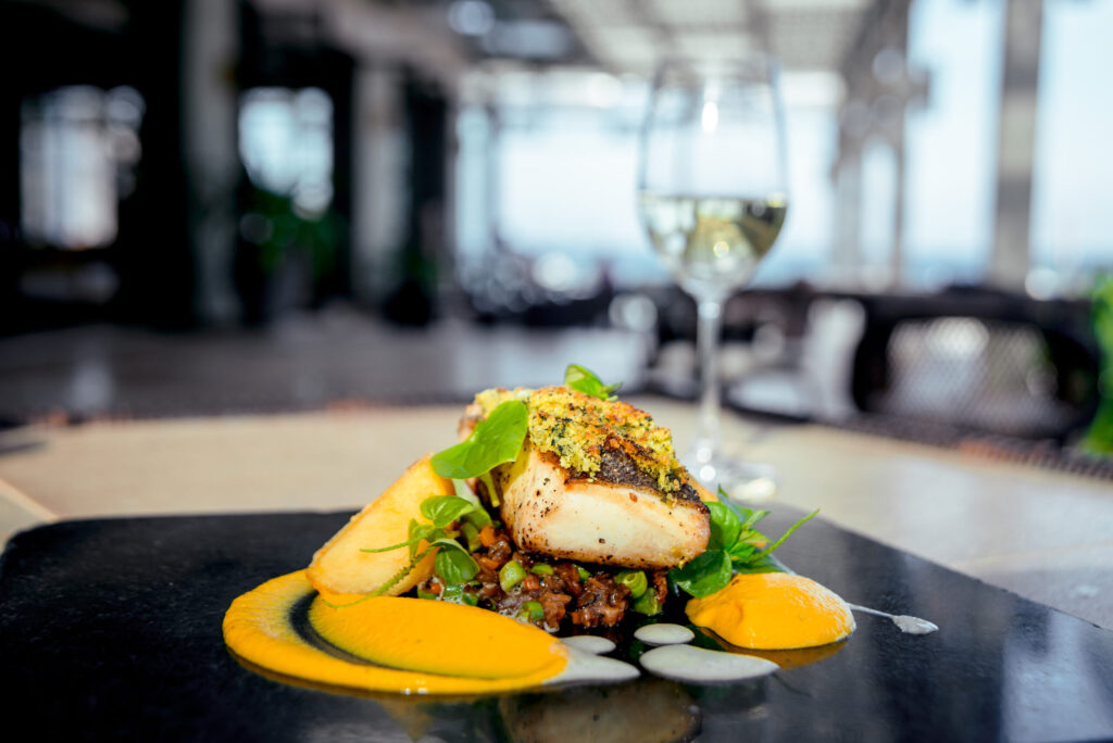 Hálibut con costra, romesco de albaricoques y lentejas beluga estofadas con pera